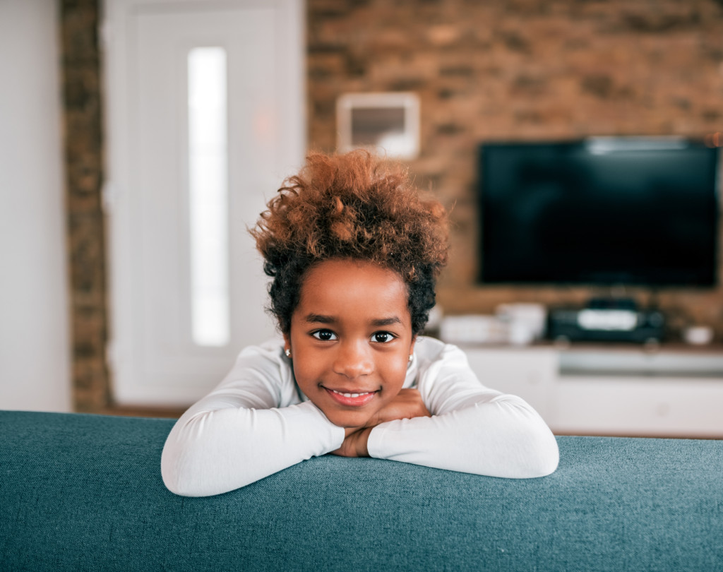 child sitting on couch with arms crossed waiting for virutal teacher