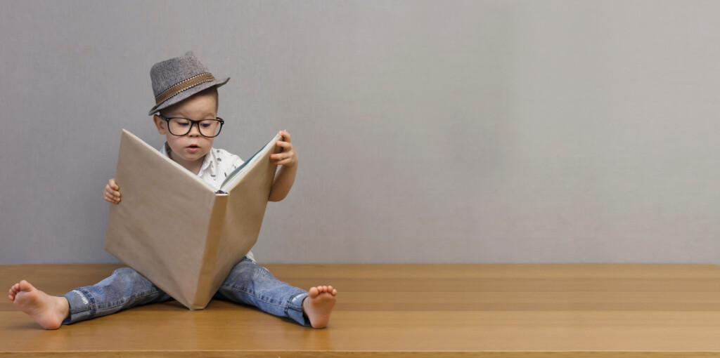 jeune enfant intelligent assis sur le plancher apprenant un livre sur plusieurs langues