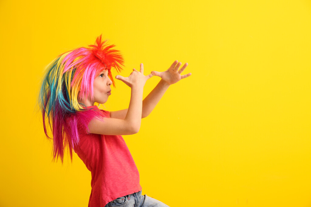 enfant avec une personnalité avec perruque multicolore et arriere plan jaune